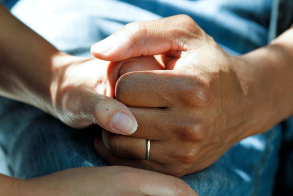 Close up shot of two people holding hands